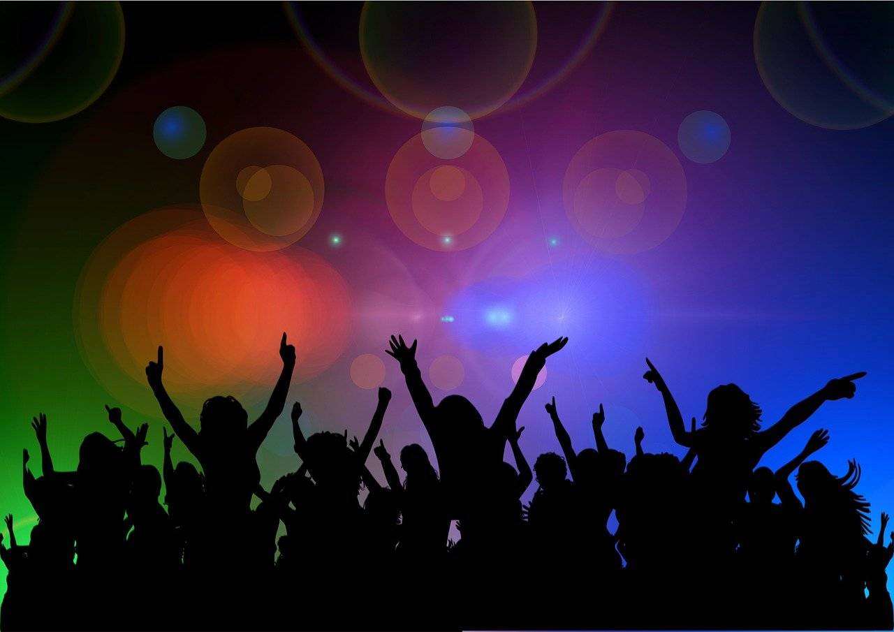 Silhouetten feiernder Menschen auf einer Party mit bunten Lichtern, symbolisiert die Wirkung von EuphoriX für soziale Interaktion und Euphorie
